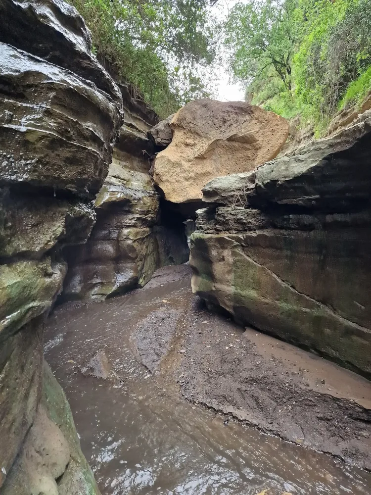 A narrow rock passage with layered walls